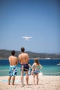 Young people flying a drone by remote control on a beach