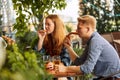 Young people, friends, couple sitting on open air restaurant, cafe pub, drinking beer, talking, having fun together Royalty Free Stock Photo