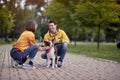 Young people getting know each other by talking about pets in autumn park