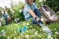 Volunteering. Young people volunteers outdoors asian girl picking plastic bottle close-up