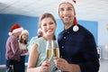 Young people with glasses of champagne celebrating Christmas at corporate party in office