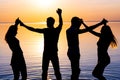 Young people, guys and girls are dancing couples at sunset background, silhouettes Royalty Free Stock Photo