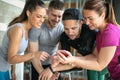 Young people in gym. Friends workout in gym and using smart phone. Royalty Free Stock Photo