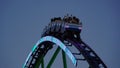 Overview of the mobile roller coaster "Alpina Bahn" at a funfair at night with illuminated train Royalty Free Stock Photo