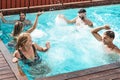 Young people having fun in exclusive pool party - Happy friends enjoying summer holidays in swimming pool Royalty Free Stock Photo