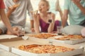 Young people having fun at party with delicious pizza indoors Royalty Free Stock Photo