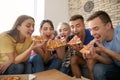 Young people having fun at party with delicious pizza indoors Royalty Free Stock Photo