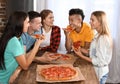 Young people having fun at party with delicious pizza indoors Royalty Free Stock Photo