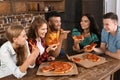 Young people having fun at party with delicious pizza indoors Royalty Free Stock Photo