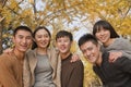 Young people having fun and playing piggyback in the park in autumn Royalty Free Stock Photo