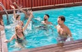 Young people having fun in villa exclusive party inside swimming pool - Happy friends enjoying summer time - Holidays and Royalty Free Stock Photo