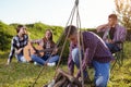 Young people having picnic, girl playing guitar Back focus