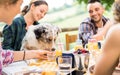Young people at healthy pic nic breakfast with cute dog in countryside farm house - Happy friends millennials having fun together Royalty Free Stock Photo