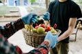 Young people helping old woman with products. Hands in gloves, help during quarantine through coronavirus infection. Volunteering