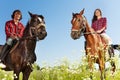 Young people horseback riding in flowery meadows Royalty Free Stock Photo