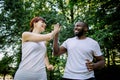 Young people, joyful multiethnic friends, African man and Caucasian woman, jogging and exercising in nature, park or Royalty Free Stock Photo