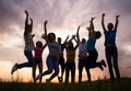 Young people jumping against the sunset sky Royalty Free Stock Photo