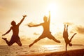 Young people jumping on the beach with sunset Royalty Free Stock Photo