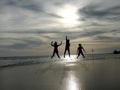 Young people jumping on the beach with sunset background Royalty Free Stock Photo