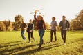 Young people with a kite run on the grass in the park. Royalty Free Stock Photo