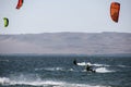 people kitsurfing in a paracas bay of peru with blue water and drops in the air and mountains in the background-june 2020