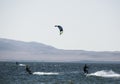 people kitsurfing in a paracas bay of peru with blue water and drops in the air and mountains in the background-june 2020