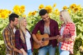 Young people listening guy playing guitar friends drinking beer bottles outdoor countryside Royalty Free Stock Photo