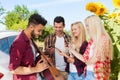 Young people listening guy playing guitar friends drinking beer bottles outdoor countryside Royalty Free Stock Photo