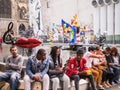 Young people lounge and talk on the wall surrounding the Fontaine de Stravinsky in central Paris, France