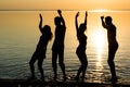 Young people, men and women, students are dancing at sunset back Royalty Free Stock Photo