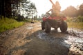 Young people on an off road adventure. Man driving quad with girlfriend sitting behind him, and enjoying the ride in mountains Royalty Free Stock Photo