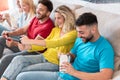 Young people playing console game while eating delivery asian food at home - Happy millennial friends having fun at house weekend Royalty Free Stock Photo