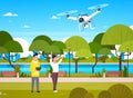 Young People Playing With Drone Copter In Park Man And Woman Using Remote Controller For Quadrocopter