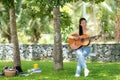 Young people playing guitar and drinking coffee after working and education on laptop in morning relax at nature garden home Royalty Free Stock Photo