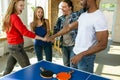 Young people playing table tennis in workplace, having fun Royalty Free Stock Photo