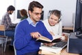 Young people reading book and using pc in library Royalty Free Stock Photo