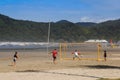 Young people relax on the beach of the Atlantic Ocean in Brazil and play beach volleyball
