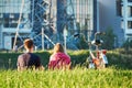 Young people rest on the grass on the industrial background