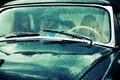 Young people driving retro car in the rain Royalty Free Stock Photo