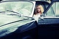 Young people in retro car in the rain Royalty Free Stock Photo