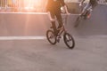 Young people riding a Bmx bike in a skate park in the background of the sunset. Bmx Concept. Bmx Bicycle Training Royalty Free Stock Photo