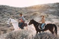 Young people riding horses doing excursion at sunset - Wild couple having fun in equestrian tour - Training, culture, passion,