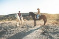 Young people riding horses doing excursion at sunset - Wild couple having fun in equestrian tour - Training, culture, passion,