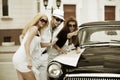 Young fashion people with road map next a retro car Royalty Free Stock Photo