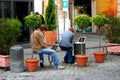 Young people sit on the bench in Rome and looking at the top lap.