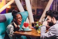 Young people sitting in a cafe and talking. Young man and woman meeting at cafe table. Royalty Free Stock Photo