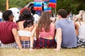 Young people sitting outdoors at a music festival, back view Royalty Free Stock Photo