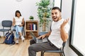 Young people sitting at waiting room working with laptop celebrating victory with happy smile and winner expression with raised Royalty Free Stock Photo