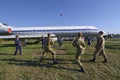 Young people soldiers, pilots and stewardesses playing volleyball, landed aircraft on a background. Kyiv, Ukraine