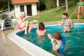 Young people spraying each other in pool